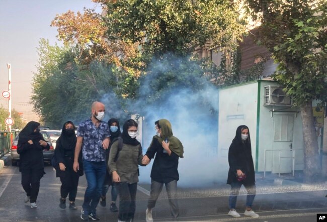 FILE - In this Oct. 1, 2022, photo taken by an individual not employed by the Associated Press and obtained by the AP outside Iran, tear gas is fired by security to disperse protestors in front of the Tehran University, Iran.