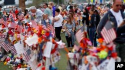 FILE - People visit a makeshift memorial honoring the victims of the Oct. 1, 2017, mass shooting in Las Vegas, on Nov. 12, 2017.