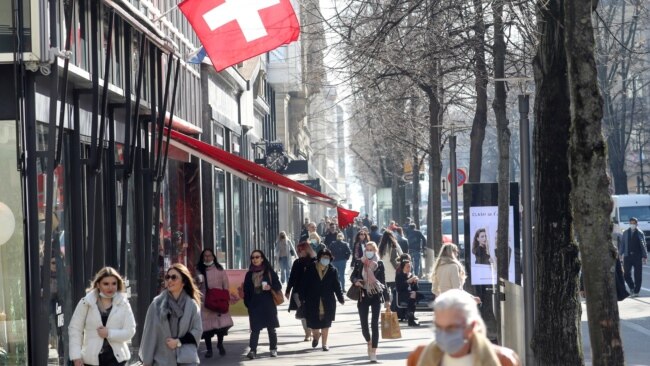FILE - Shoppers walk along the Bahnhofstrasse shopping street in Zurich, Switzerland, March 1, 2021.