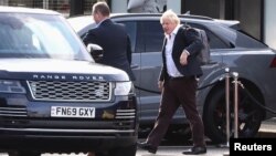 Former British Prime Minister Boris Johnson walks, at Gatwick Airport, near London, Oct. 22, 2022.