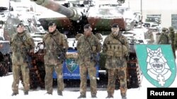 German soldiers pose in front of a Leopard 2 tank during German Minister of Defense Ursula von der Leyen's visit to German troops deployed as part of NATO enhanced Forward Presence battle group in Rukla military base, Lithuania, Feb. 4, 2019. 