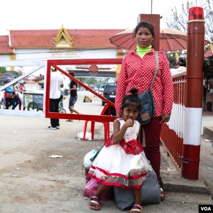 Mother standing near border gate with her six-year-old daughter standing in front of her.