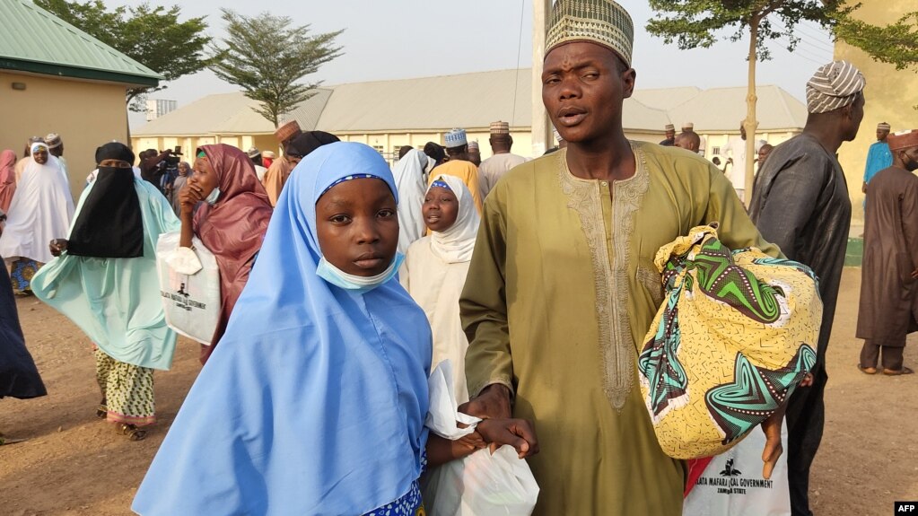 Une fille kidnappée réagit alors qu'elle retrouve un membre de sa famille à Jangebe, dans l'État de Zamfara, au Nigeria, le 3 mars 2021.