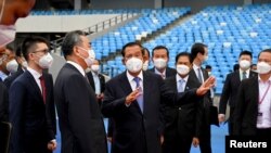 Prime Minister Hun Sen gestures next to China's Foreign Minister Wang Yi as they attend a handover ceremony at the Morodok Techo National Stadium, which will be the main venue for Cambodia’s 2023 SEA Games, in Phnom Penh, Cambodia, September 12, 2021. REUTERS