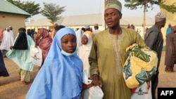 Une fille kidnappée réagit alors qu'elle retrouve un membre de sa famille à Jangebe, dans l'État de Zamfara, au Nigeria, le 3 mars 2021.