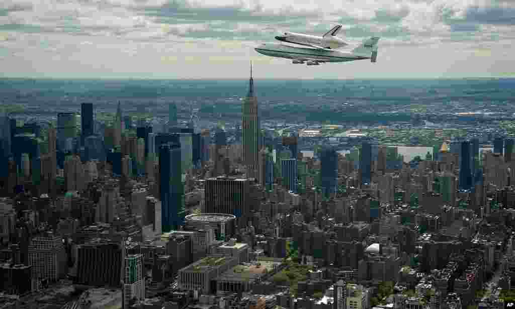 Space shuttle Enterprise, mounted atop a NASA 747 Shuttle Carrier Aircraft, flies near the Empire State Building, April 27, 2012, in New York. Enterprise will be placed on a barge that will eventually be moved by tugboat up the Hudson River to the Intrep