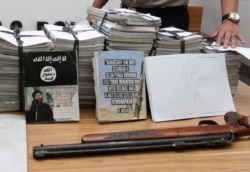 FILE - Indonesian police show scores of notebooks inscribed with Islamic State propaganda seized during a raid on the home of suspected militant during a press conference at police headquarters in Jakarta, June 30, 2017.