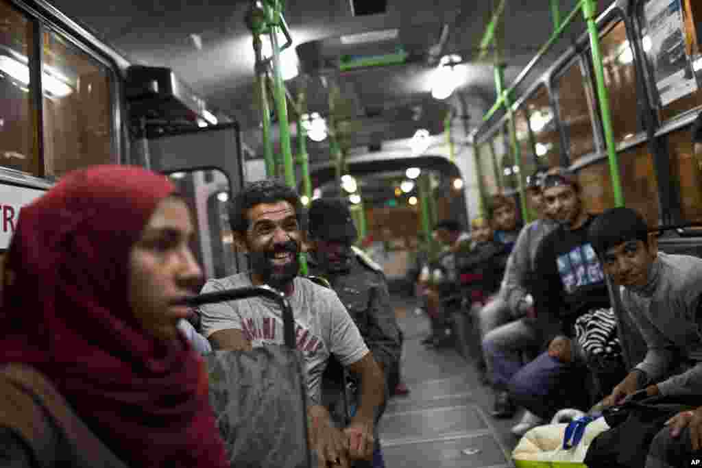 A man laughs as he sits inside a bus provided by Hungarian authorities for migrants and refugees at Keleti train station in Budapest, Hungary, Sept. 5, 2015. 