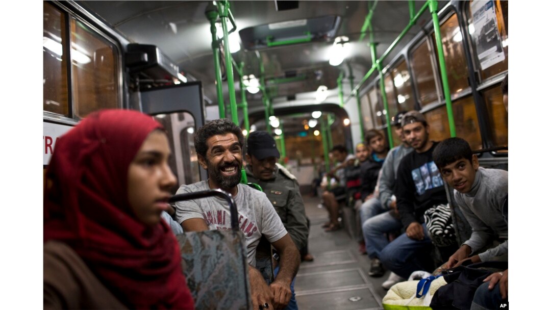 Seorang pria tertawa saat duduk di sebuah bus yang disediakan oleh pemerintah Hungaria untuk migran dan pengungsi di stasiun kereta Keleti di Budapest, Hungaria, 5 September 2015.