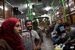 Seorang pria tertawa saat duduk di sebuah bus yang disediakan oleh pemerintah Hungaria untuk migran dan pengungsi di stasiun kereta Keleti di Budapest, Hungaria, 5 September 2015.