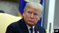 FILE - President Donald Trump in the Oval Office of the White House, Oct. 19, 2017, in Washington.