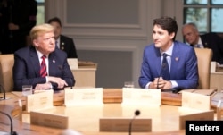 FILE - Canada's Prime Minister Justin Trudeau, right, and U.S. President Donald Trump participate in the working session at the G-7 Summit in the Charlevoix town of La Malbaie, Quebec, Canada, June 8, 2018.