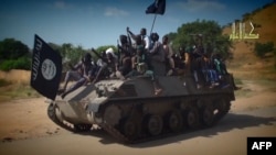 FILE - A screengrab from a Boko Haram video shows Boko Haram fighters parading on a tank in an unidentified town. 