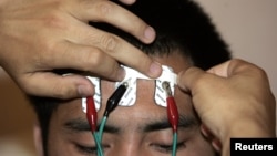 Electrodes are attached to the head of a drug addict to monitor his skin temperature and muscle electrical currents during psychological treatment at the Xin'an Labor Camp in Beijing, June 2007 file photo. 