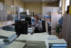 Seorang karyawan bekerja di kantor Organisasi Tenaga Kerja Yunani (OAED) di pinggiran Kalamaki dekat Athena, Yunani, 15 Februari 2021. (Foto: REUTERS/Costas Baltas)