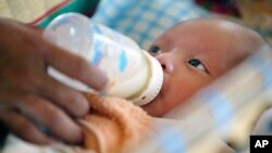 Cambodian orphan Vannak, a 2 month old boy, is fed formula milk by a nanny at Chrey Chao commune orphanage on the outskirts of Phnom Penh, file photo. (AP Photo/Andy Eames)