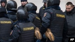 FILE - Russian police officers detain an opposition activist outside a court room in Moscow, Russia.