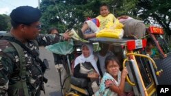 Residents fleeing the besieged city of Marawi are questioned at a checkpoint by government soldiers, May 26, 2017.