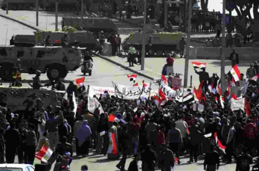 Egyptian Army tanks form a check point as Egyptian pro-Mubarak supporters shout slogans during a march in Cairo, Egypt, Tuesday, Feb. 1, 2011. Egyptian authorities battled to save President Hosni Mubarak's regime with a series of concessions and promises 