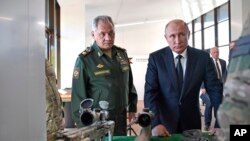 ရုရှားနိုင်ငံလုပ် လက်နက်များကို ကြည့်ရှုနေသည့် ရုရှားသမ္မတ ပူတင်နှင့် ကာကွယ်ရေးဝန်ကြီး Sergei Shoigu. (စက်တင်ဘာ ၁၉၊ ၂၀၁၈)