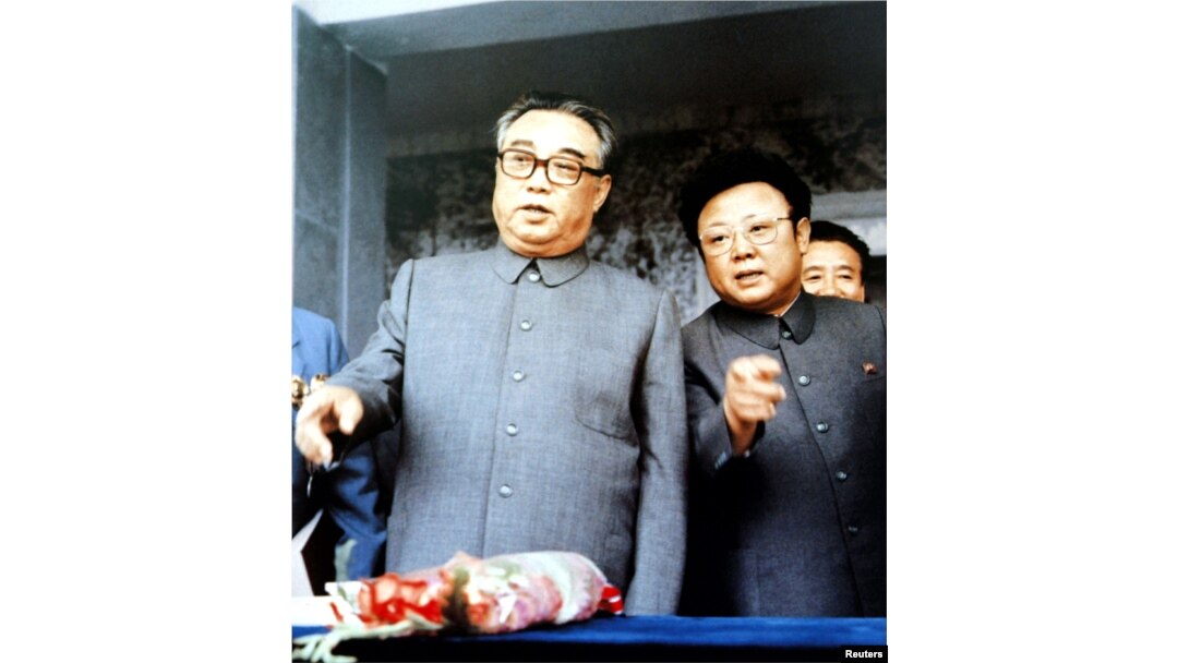 1983年9月朝鲜创始人金日成(左)与他的儿子金正日在群众大会上。