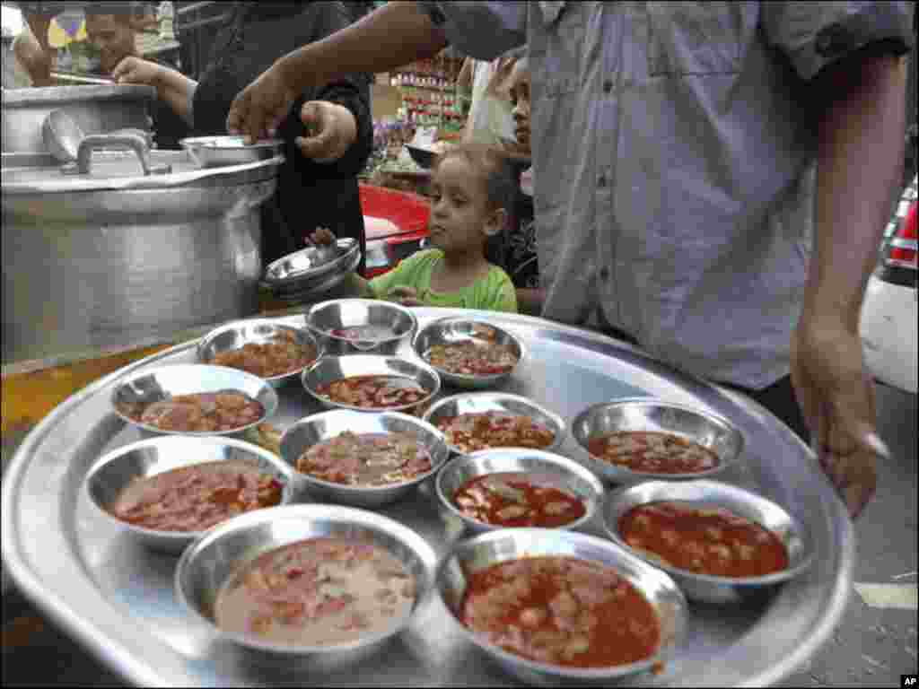 Children look as volunteers prepare food for an Iftar meal for the needy during the holy month of Ramadan in Cairo.