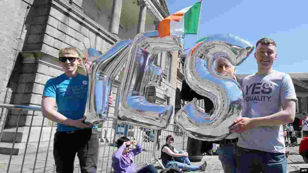 Para pendukung pernikahan sesama jenis memegang balon &quot;Yes&quot; saat menunggu pengumuman hasil referendum di Kastil Dublin (23/5). (AFP/Paul Faith)