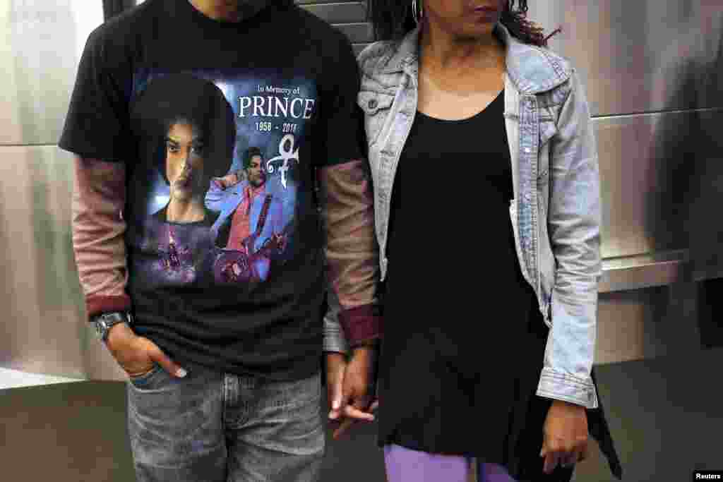 A couple watches on as fans gather at Harlem's Apollo Theater to celebrate the life of deceased musician Prince in the Manhattan borough of New York, April 21, 2016. 