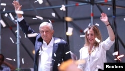 Presidential candidate Andres Manuel Lopez Obrador gestures with his wife Beatriz Gutierrez Muller as he addresses supporters in Mexico City, Mexico, July 1, 2018. 