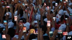 People use their cell phones to take images before the speech of President Recep Tayyip Erdogan at the Democracy and Martyrs' Rally in Istanbul, Aug. 7, 2016.