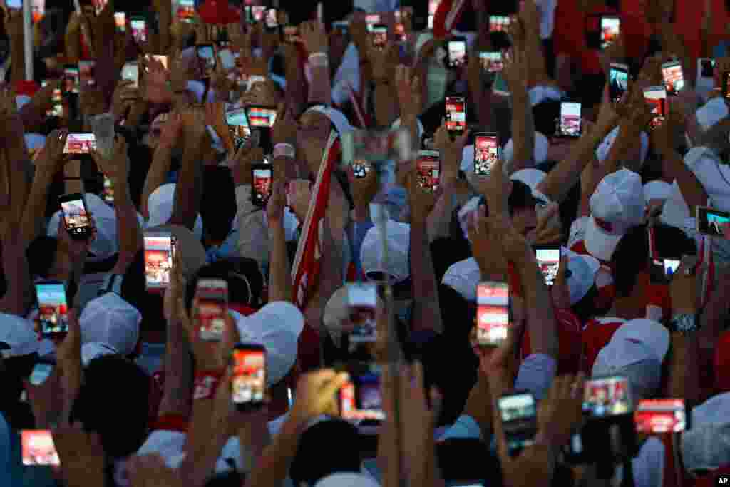 Turkish people use their cell phones to take images before the speech of President Recep Tayyip Erdogan at the Democracy and Martyrs' Rally in Istanbul, Aug. 7, 2016.