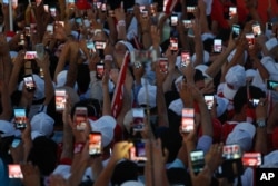 Turkish people use their cell phones to take images before the speech of President Recep Tayyip Erdogan at the Democracy and Martyrs' Rally in Istanbul, Aug. 7, 2016.
