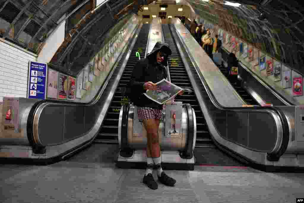 Seorang pria membaca surat kabar pada hari &quot;tanpa celana panjang di kereta bawah tanah&quot; di stasiun Liverpool, London, Inggris.
