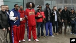 Flamboyant former NBA star Dennis Rodman, fifth from right, poses with three members of the Harlem Globetrotters basketball team, Pyongyang Airport, North Korea, Feb. 26, 2013.