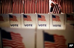 FILE - A voter steps out of a booth after marking his ballot at a polling site for the New Hampshire primary, Feb. 9, 2016. New Hampshire is appealing a decision that allows voters to take pictures inside voting booths.