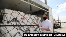 FILE - Sean Jones, USAID mission director, Ethiopia, inspects the first of two shipments of 840,060 doses of Pfizer COVID-19 vaccine, which arrived at Addis Ababa on Jan. 24, 2022. (Photo courtesy US Embassy in Ethiopia)