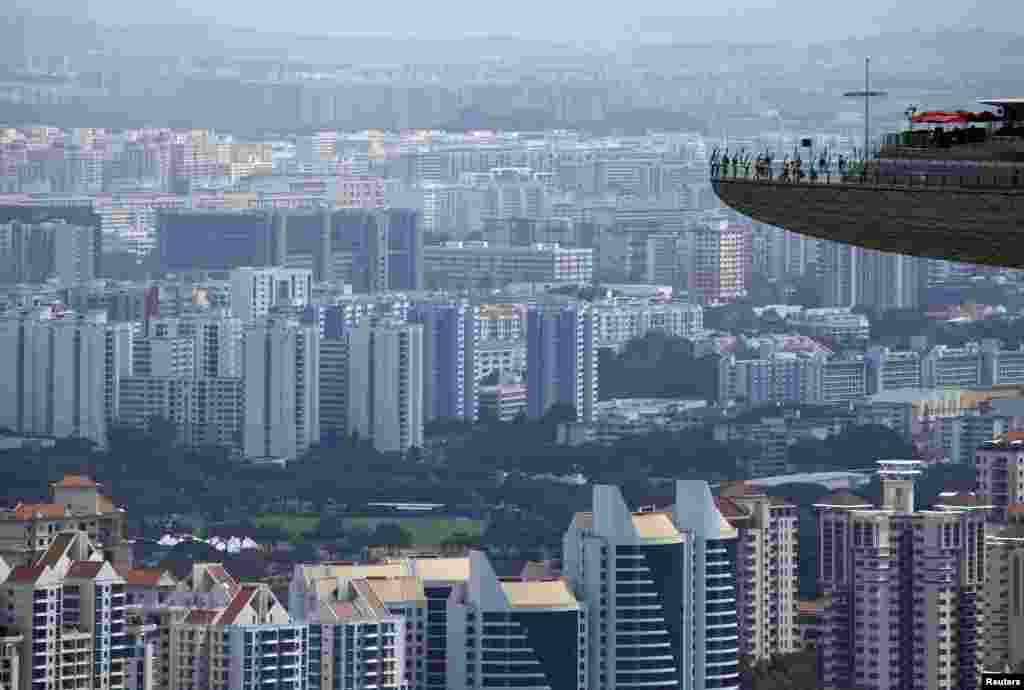 Singapur&#39;da Marina Bay Sands&#39;daki kuleden etrafı izleyen insanlar