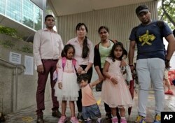 Buscadores de asilo, de izquierda a derecha: Ajith Pushpa Kumara, Vanessa Mae Rodel y su hija Keana, Nadeeka Dilrukshi Nonis y su hijo Dinath y su hija Sethmundi Kellapatha, y Supun Thilina Kellapatha, posan fuera del edificio de la inmigración de Hong Kong. Foto de archivo. Solo Rodel y su hija Keana han recibido asilo en Canadá. Los demás corren riesgo de deportación a su país Sri Lanka por haber dado albergue al estadounidense Edward Snowden, buscado por EE.UU. y refugiado en Rusia ahora.