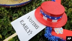  An early voting sign lies on the grass at an early voting celebration outside of Jackson Memorial Hospital, on the first day of early voting in Miami-Dade County for the general election, Oct. 24, 2016, in Miami, Florida. 