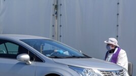 FILE PHOTO: A priest wearing a protective mask gives a 