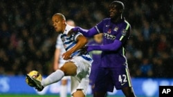 Bobby Zamora de QPR y Yaya Touré de Manchester City luchan por el balón en el partido por la Liga Premier.