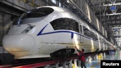 Seorang pekerja membersihkan kereta api berkecepatan tinggi Harmony CRH380B di Shenyang, propinsi Liaoning (23/12). Tiongkok mulai mengoperasikan rel kereta api kecepatan tinggi terpanjang di dunia, Rabu (26/12).