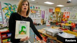 La maestra de kindergarten de Ethan muestra el libro favorito y el pupitre del niño en la escuela de Midland City, en Alabama.