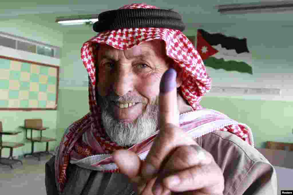 A man shows his ink-stained finger after voting at a polling station in Amman. Jordanians voted in their first parliamentary elections since the Arab Spring revolts.