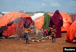 An internally displaced Somali family is seen outside their makeshift shelter at a camp after fleeing from drought stricken regions in Baidoa, west of Somalia's capital Mogadishu, April 9, 2017.
