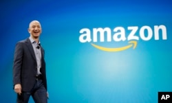 FILE - Amazon CEO Jeff Bezos walks onstage for the launch of the new Amazon Fire Phone, in Seattle, June 16, 2014.