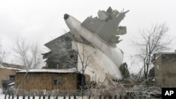 The tail of a crashed Turkish Boeing 747 cargo plane lies at a residential area outside Bishkek, Kyrgyzstan, Jan. 16, 2017.