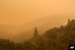 Smoke from a wildfire spreads over woods, as seen from White Rock in Carmel Valley, southeast of Monterey, Calif., Wednesday, July 27, 2016.