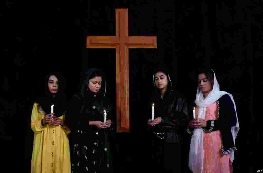 Fotoğraftaki Pakistanlı kızlar, Lahor&#39;da bir kiliseye yapılan intihar saldırısında hayatını kaybeden kurbanlar için dua ediyor.