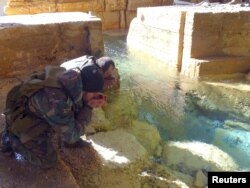 Syrian government soldiers drink from a water pumping station in the village of Ain al-Fija in the Wadi Barada valley near Damascus.